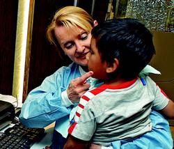 Hello TDOT: 5-year-old Valentin Ramirez prepares for digital panoramic X-rays May 18 (left), and Dr. Habjan explains the results (right). Like many children at San Juan Elementary, Valentin needs significant restorative work.