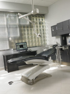 The centerpiece of the Excellent Periodontist Babcock office, and one of the first rooms that patients see, is this large operatory, lined with glass block walls and featuring Midmark Elevance chair and custom cabinetry.