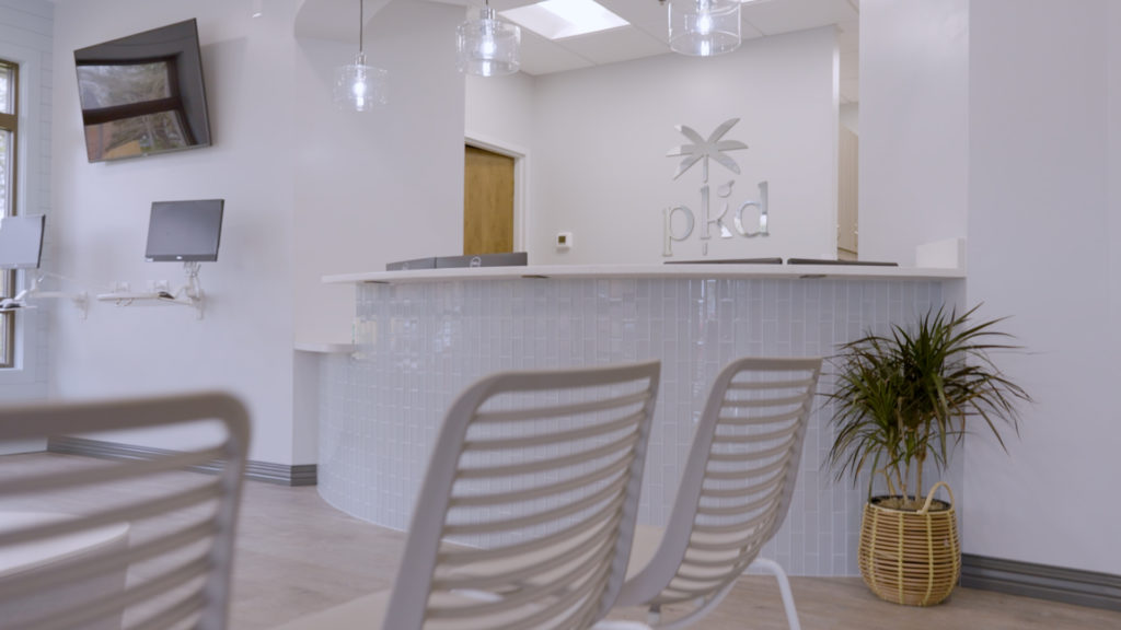 The sleek, modern waiting room, which features shiplap walls, sea glass-inspired tiles and an overall calming color palette of whites, soft blues and grays.